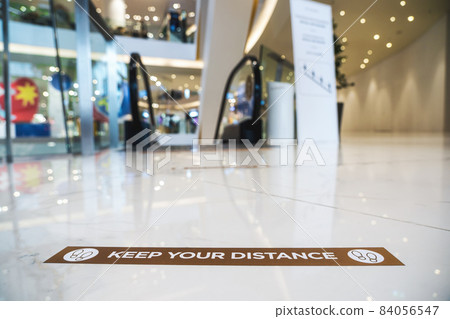 Keep Your Distance Text on the floor before escalator in department store Keep Your Distance Text on the floor before escalator in department store 84056547