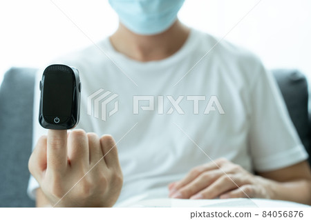 Man using blood oxygen meter. Man using blood oxygen meter. 84056876