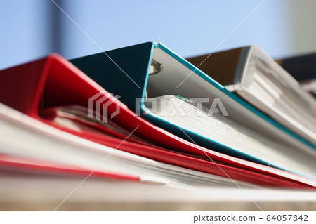 Stack of colourful folders for documents on table 84057842