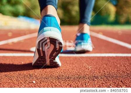 Blue sport shoes at stadium track 84058701