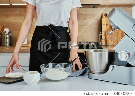 Woman cooking at kitchen and using kitchen machine 84058729