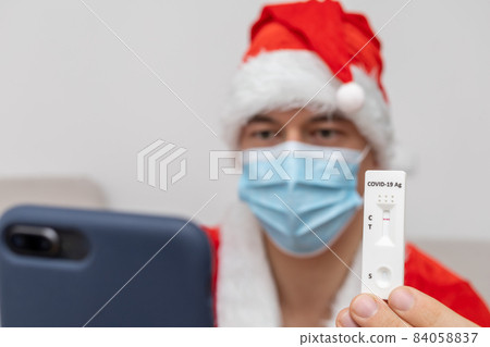 man dressed in Santa Claus hat showing test result man dressed in Santa Claus hat showing test result 84058837