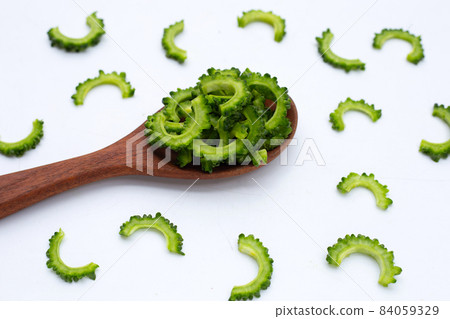Sliced bitter gourd in wooden spoon on white background. 84059329