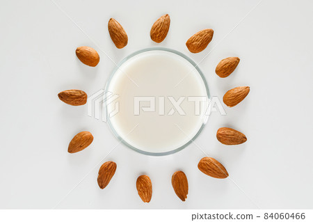 A glass of almond milk on a white background. Lactose-free vegetable diet milk. Gluten free almond drink on a blue background. Super Food - A glass of almond milk for a healthy diet. Trending food, A glass of almond milk on a white background. Lactose-free vegetable diet milk. Gluten free almond drink on a blue background. Super Food - A glass of almond milk for a healthy diet. Trending food, 84060466