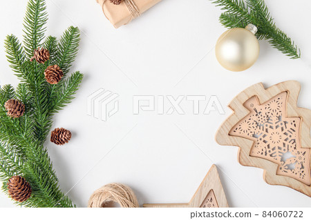 Christmas background frame of fir twigs and wooden home decoration chistmas tree on white background, top view. Christmas background frame of fir twigs and wooden home decoration chistmas tree on white background, top view. 84060722