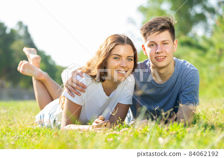 Cheerful girl with friend are resting on grass 84062192