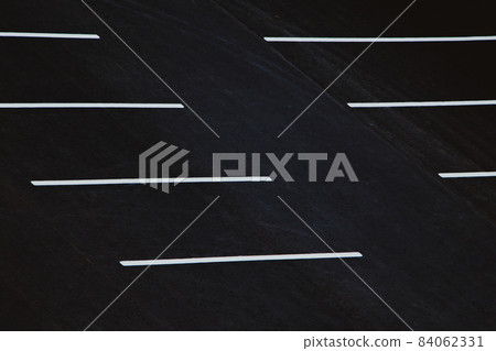 Empty parking during quarantine in the city. White markings for cars on black asphalt. Empty parking during quarantine in the city. White markings for cars on black asphalt. 84062331