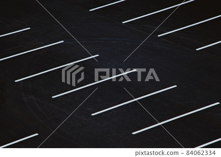 Empty parking during quarantine in the city. White markings for cars on black asphalt. Empty parking during quarantine in the city. White markings for cars on black asphalt. 84062334
