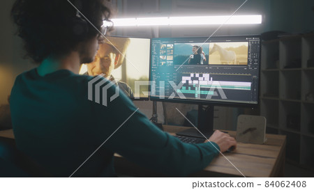 Male freelancer editing video at night Male freelancer editing video at night 84062408