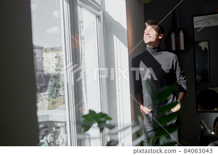 Male happy smiling hairdresser at his modern salon 84063043