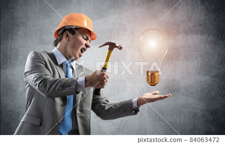 Businessman going to crash with hammer dollar Businessman going to crash with hammer dollar 84063472