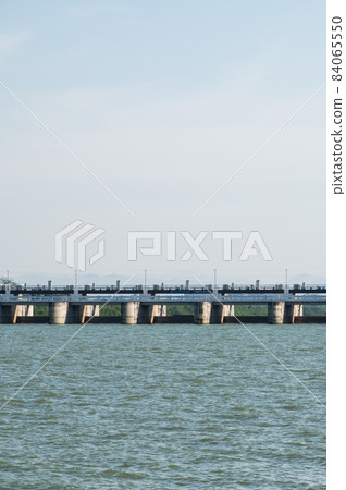 The many large gates of the service spillway on the reservoir dam. 84065550