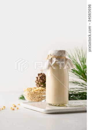 Cedar nut milk and nuts on white background. Alternative plant based milk. Cedar nut milk and nuts on white background. Alternative plant based milk. 84065696