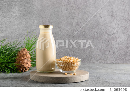 Vegan cedar nut milk on gray background. Non dairy alternative milk. Vegan cedar nut milk on gray background. Non dairy alternative milk. 84065698