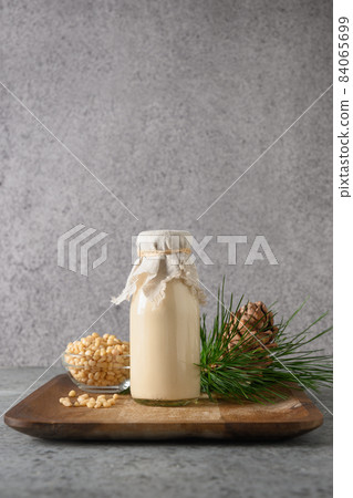 Vegan cedar nut milk on gray background. Non dairy alternative milk. Vegan cedar nut milk on gray background. Non dairy alternative milk. 84065699