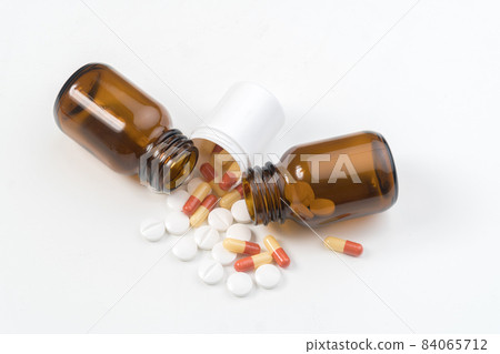 Pills and capsules falling out of bottles 84065712