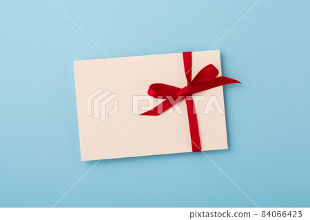 Letter with red bow ribbon on blue background Letter with red bow ribbon on blue background 84066423