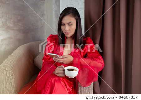 Woman looking at a smartphone Woman looking at a smartphone 84067817