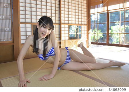 A young woman in a bikini swimsuit relaxing in a Japanese-style room in an old folk house 84068099