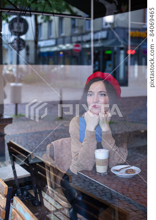 Romantic pretty woman outside cafe window Romantic pretty woman outside cafe window 84069465