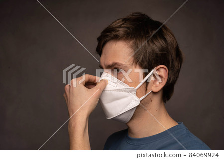 Young man with face mask on grey Young man with face mask on grey 84069924