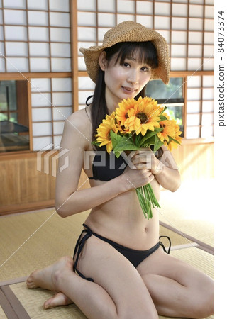 一個穿著黑色比基尼泳裝的年輕女子在老民居的日式房間裡放鬆 84073374