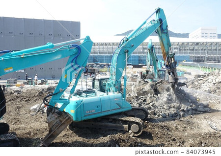 Building demolition work site with large heavy machinery demolished 84073945