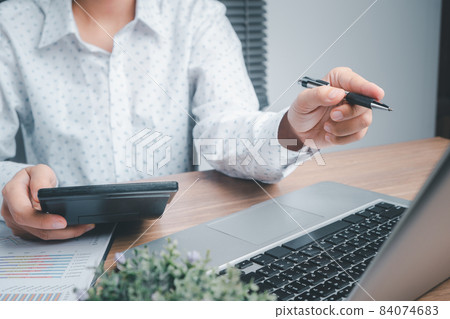 Businesswoman working with calculator and business chart and laptop computer on desk table in office.Business analysis and strategy concept. 84074683
