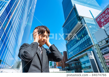 A young businessman who is worried, closes his ears A young businessman who is worried, closes his ears 84074766