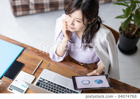 Business woman doing desk work Business woman doing desk work 84074768