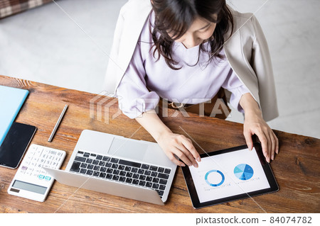 Business woman doing desk work Business woman doing desk work 84074782