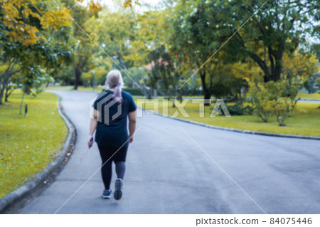 Blurred concept of overweight woman exercise walking in the park. 84075446