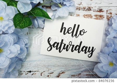 Hello Saturday Card with Blooming flower on wooden background 84076156