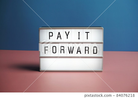 Pay It Forward word in light box on blue and pink background 84076218