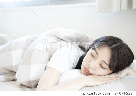 A woman sleeping in bed 84076538