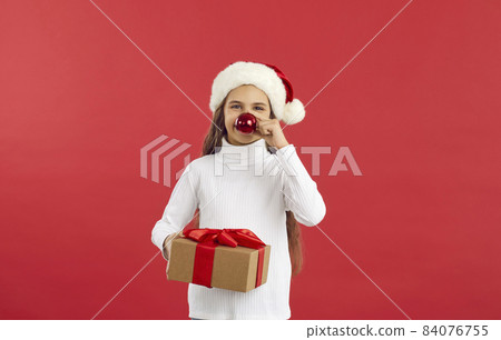 Happy little girl child with gift isolated on red studio background celebrate New Year. Smiling small kid with wrapped box greeting congratulating with Christmas holiday. Winter season concept. Happy little girl child with gift isolated on red studio background celebrate New Year. Smiling small kid with wrapped box greeting congratulating with Christmas holiday. Winter season concept. 84076755