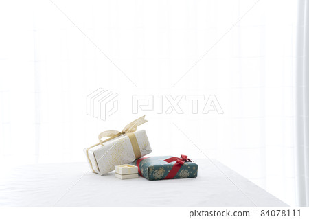 Three gifts wrapped in wrapping paper and wrapped with a ribbon 84078111