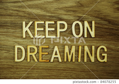 Keep On Dreaming text message on wooden background Keep On Dreaming text message on wooden background 84078255
