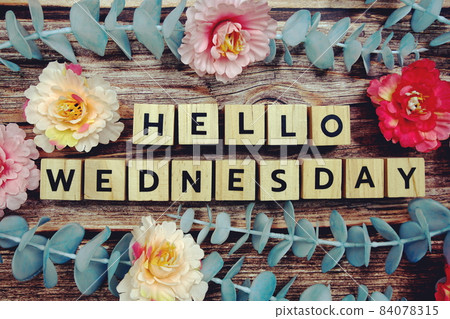 Hello Wednesday alphabet letter and flower decorate on wooden background 84078315