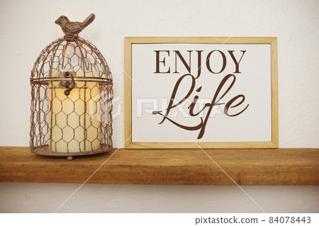 Blackboard with the text ENJOY LIFE decorate with artificial plant in watering plant on wooden shelves Blackboard with the text ENJOY LIFE decorate with artificial plant in watering plant on wooden shelves 84078443