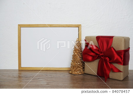 Empty mockup with christmas tree and gift box on wooden background Empty mockup with christmas tree and gift box on wooden background 84078457