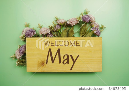 Welcome May text on wooden board with flowers frame on green background 84078495