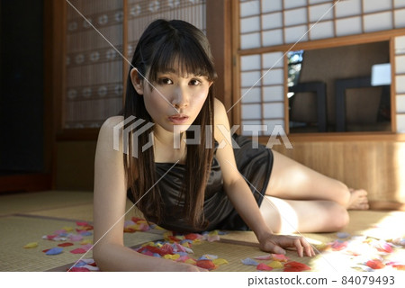 A young woman in a black camisole relaxing in a Japanese-style room in an old folk house 84079493