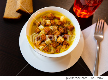 Split pea puree soup served with crispy croutons 84079679