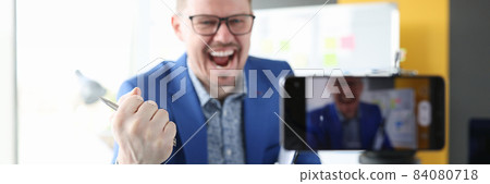 Male blogger emotionally tells interesting successful content on camera 84080718