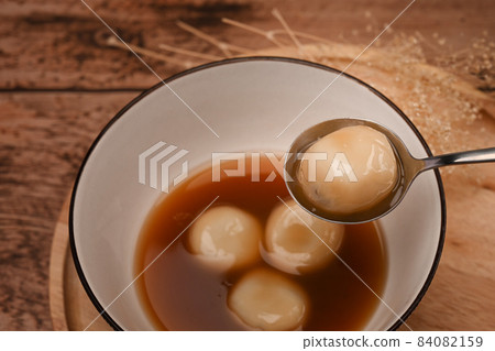 Close up sticky rice balls with sweet ginger soup on wooden table. Close up sticky rice balls with sweet ginger soup on wooden table. 84082159
