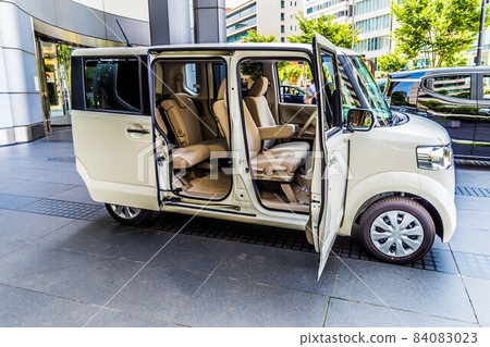 The interior of a white high-tall wagon type light car is photographed from the right side. 84083023