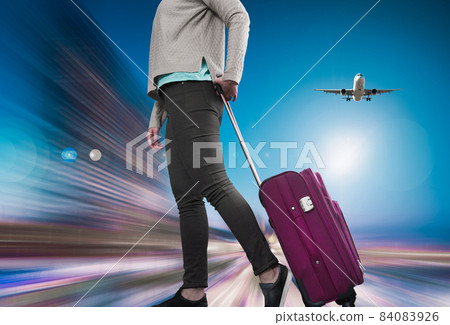Woman with suitcase awaiting aircraft 84083926