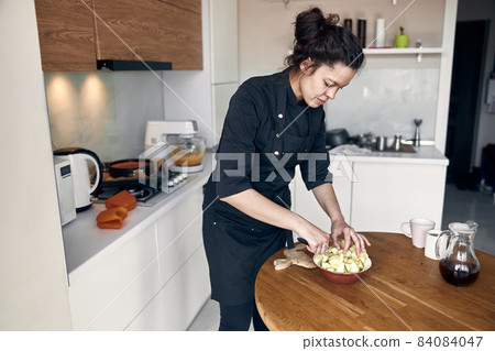 beautiful middle asian woman preparing apples for cooking at cozy stilysh kitchen beautiful middle asian woman preparing apples for cooking at cozy stilysh kitchen 84084047