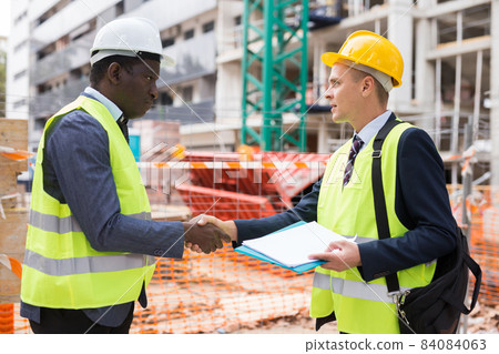 Two successful civil engineers exchange a friendly handshake Two successful civil engineers exchange a friendly handshake 84084063